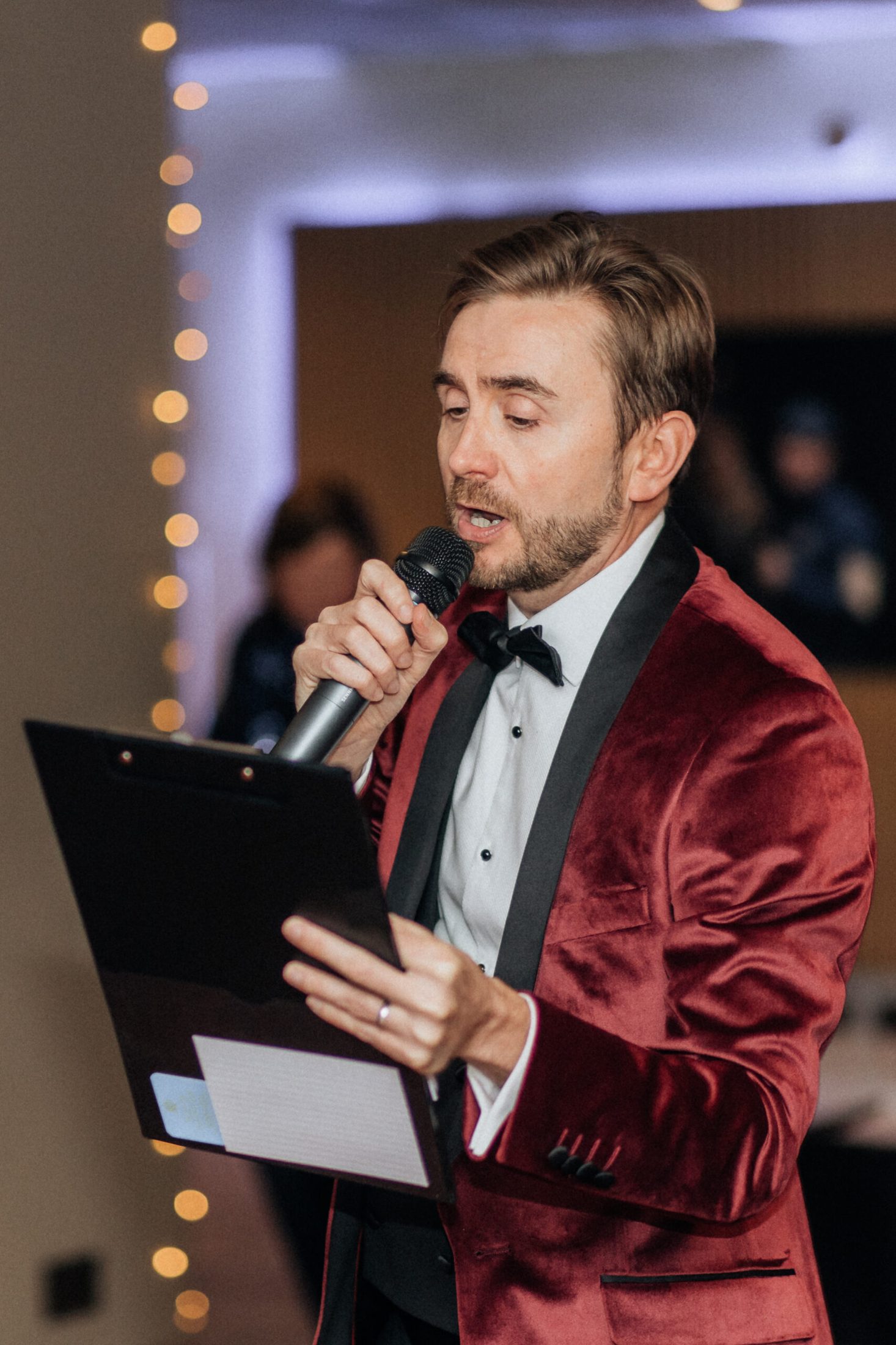 Charity auctioneer Kevin Durham running the live auction at a charity gala, addressing guests with a wireless microphone from the floor Charity auctioneer Kevin Durham running the live auction at a charity gala, addressing guests with a wireless microphone from the floor