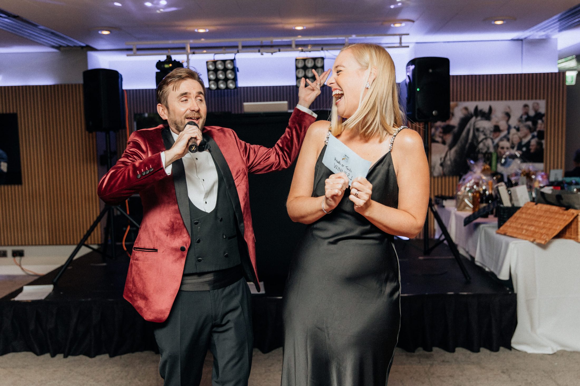 A professional charity auctioneer working the floor during a live auction.