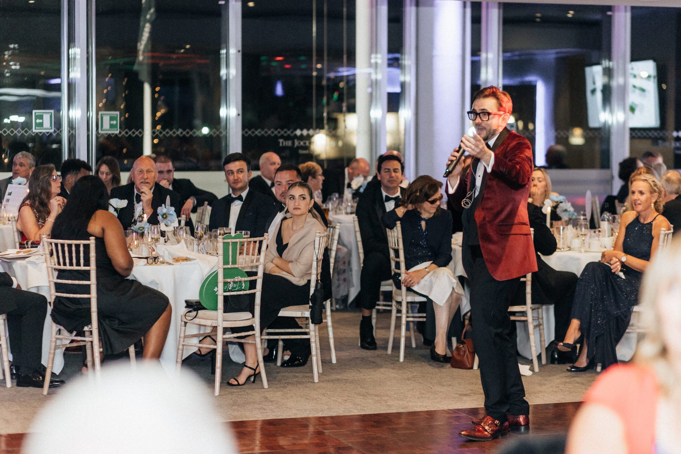 A professional charity auctioneer working the floor during a live auction. A professional charity auctioneer working the floor during a live auction.