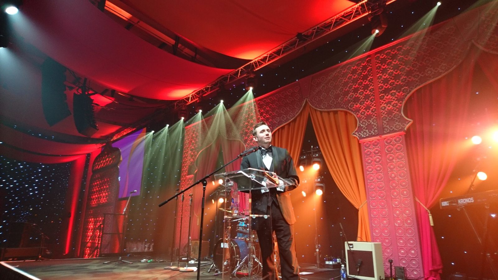 Kevin Durham hosting a black-tie charity gala from the stage