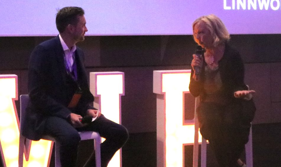 Kevin Durham interviewing a speaker on stage at a corporate conference