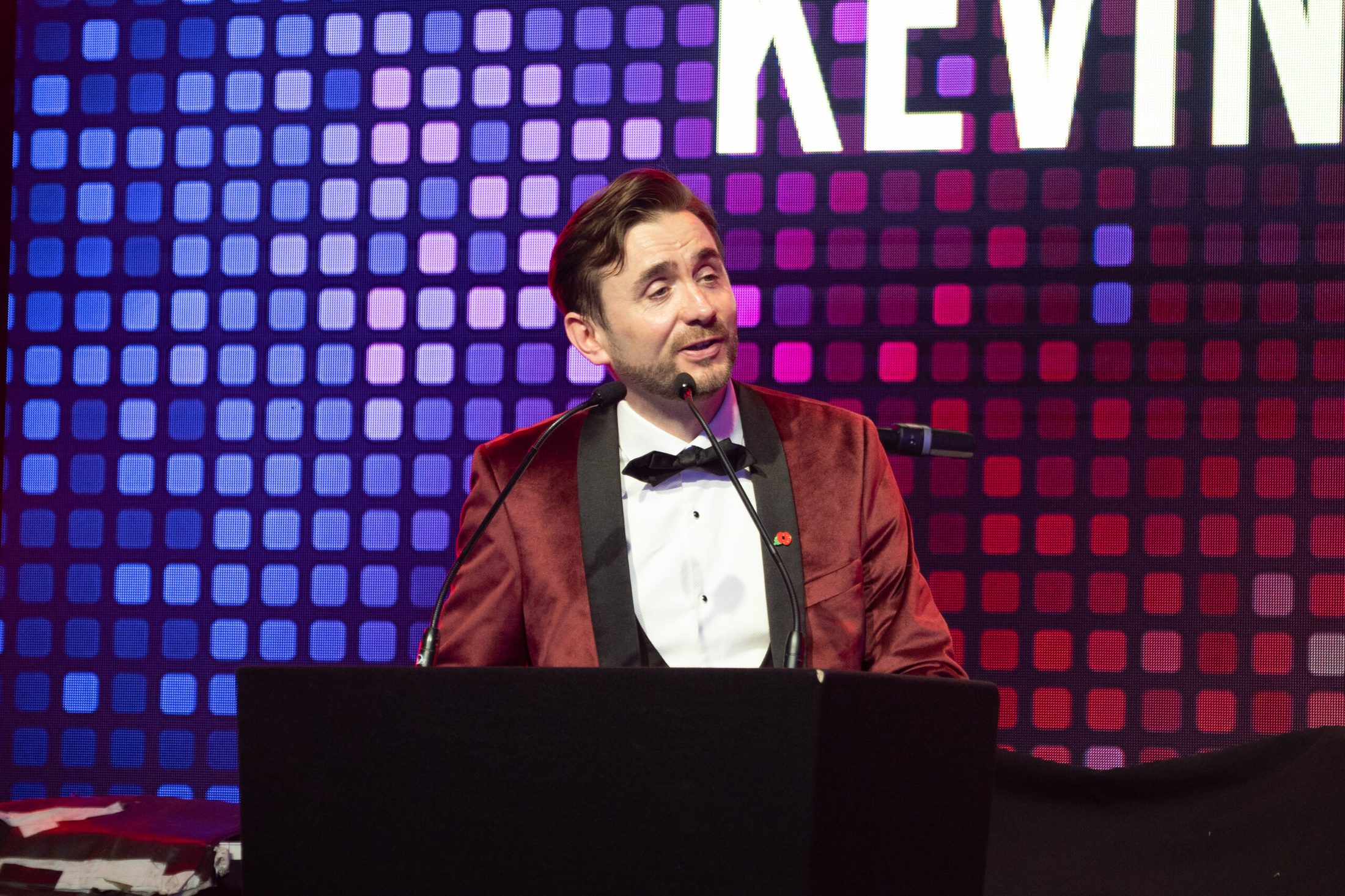 A professional charity auctioneer working the floor during a live auction. A professional charity auctioneer working the floor during a live auction.