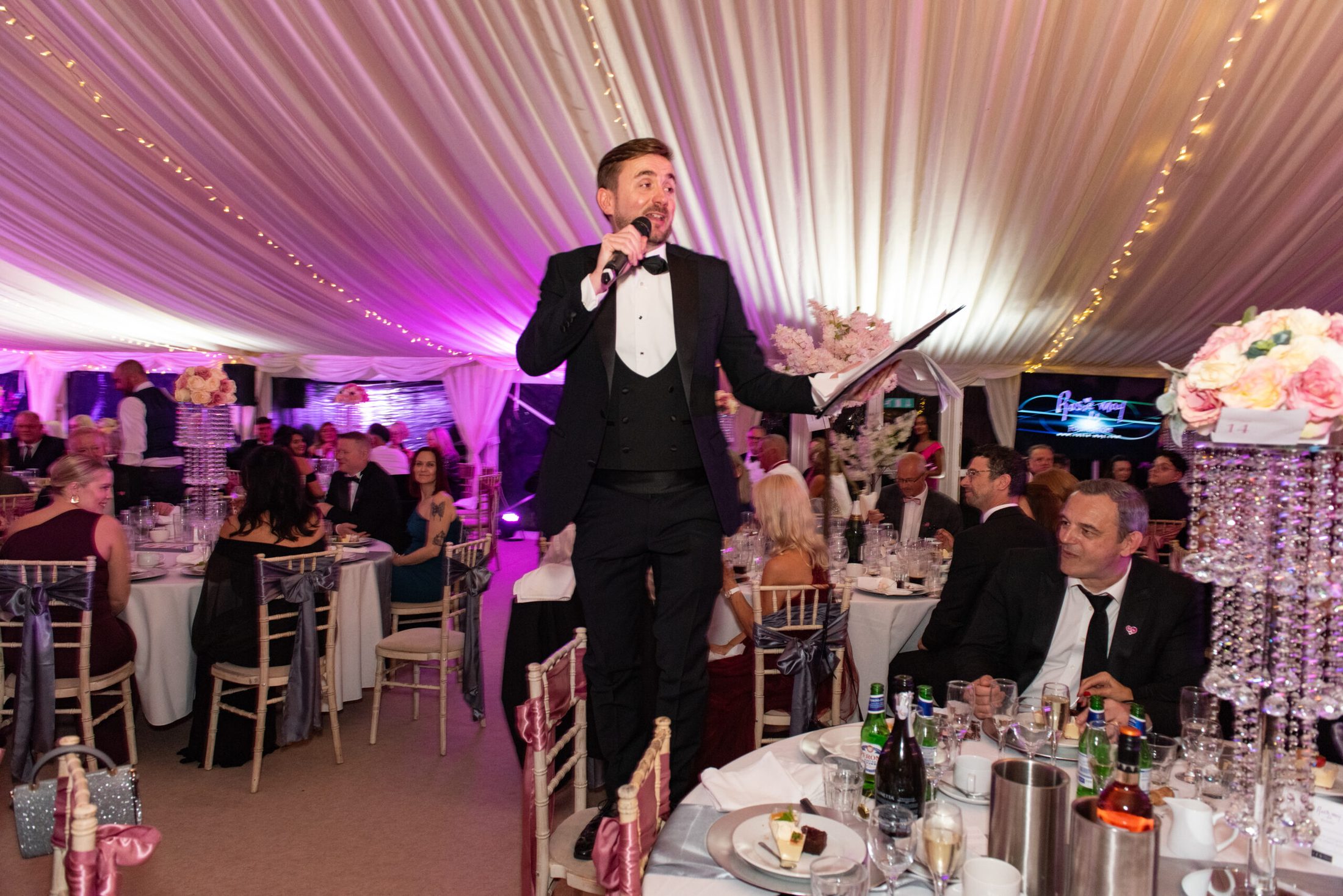 A professional charity auctioneer working the floor during a live auction. A professional charity auctioneer working the floor during a live auction.